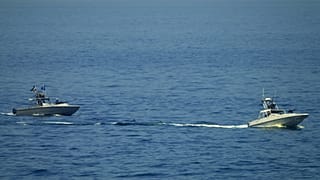 FILE: Iranian Revolutionary Guard vessels watch an American warship in the Strait of Hormuz, 19 May 2023