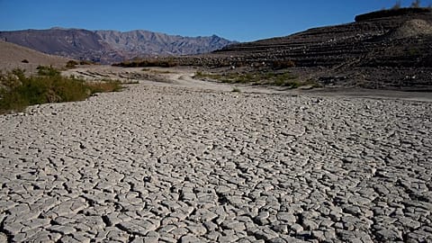 FILE - Cracked earth is visible in an area once under the water of Lake Mead