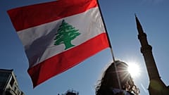 متظاهر مناهض للحكومة يحمل العلم الوطني اللبناني خلال عرض مدني منفصل في ساحة الشهداء، وسط بيروت،