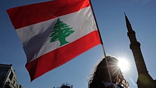 متظاهر مناهض للحكومة يحمل العلم الوطني اللبناني خلال عرض مدني منفصل في ساحة الشهداء، وسط بيروت،