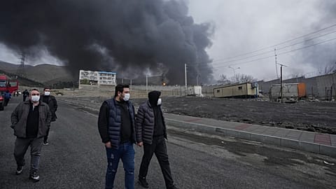 FILE - A thick plume of smoke rises March 8, 2026, from an oil storage facility struck overnight in Tehran, Iran. 