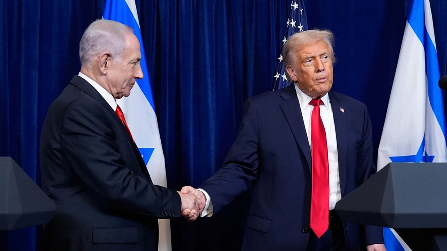 الرئيس الأمريكي دونالد ترامب يصافح رئيس الوزراء الإسرائيلي بنيامين نتنياهو خلال مؤتمر صحافي في مارالاغو بولاية فلوريدا، 29 ديسمبر 2025