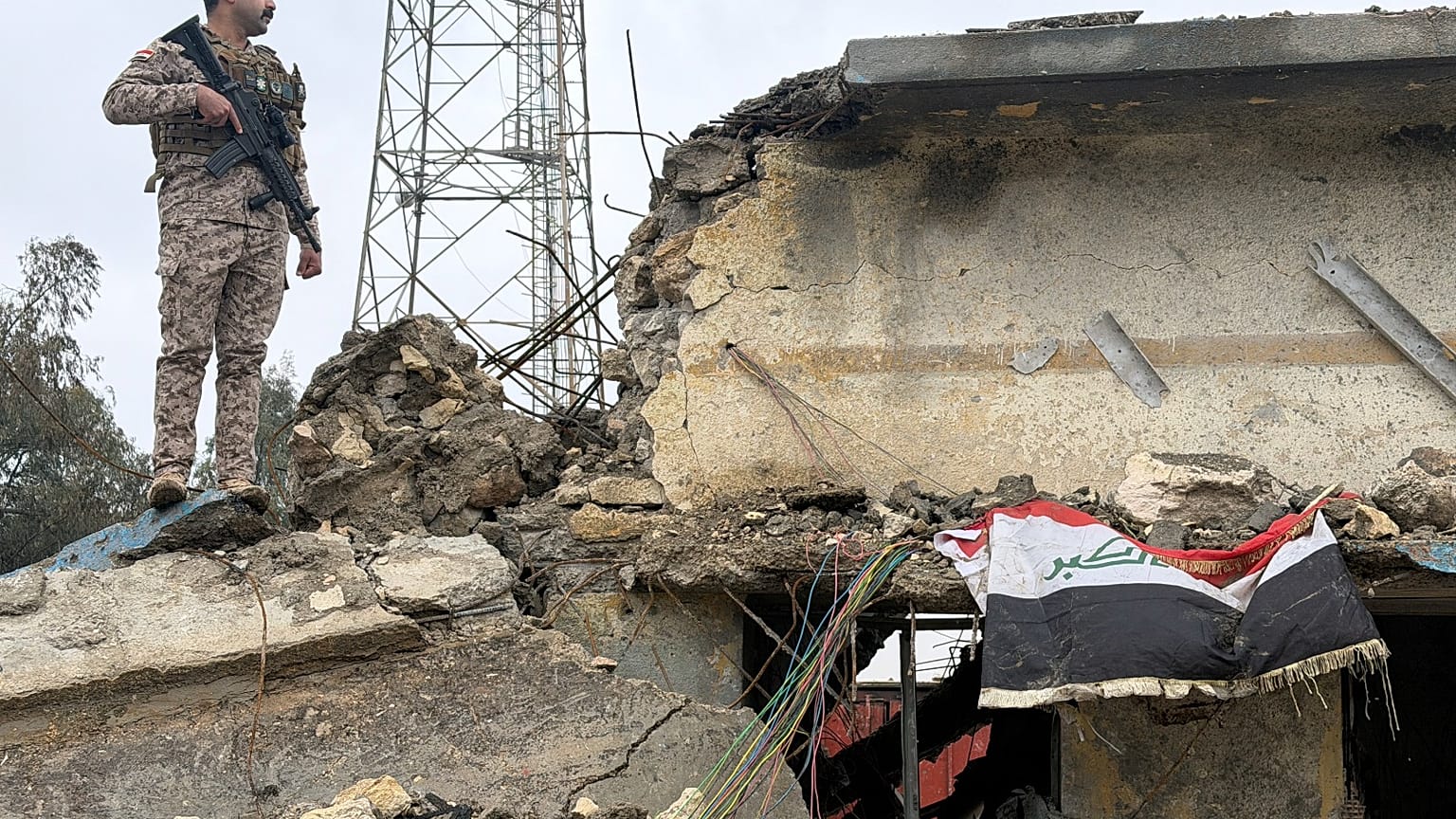 جندي عراقي يقف حارسًا فوق مبنى متضرر في قاعدة الجيش العراقي في الحبانية بعد تعرضها لغارة جوية الأربعاء، في محافظة الأنبار، العراق، الخميس 26 مارس 2026.