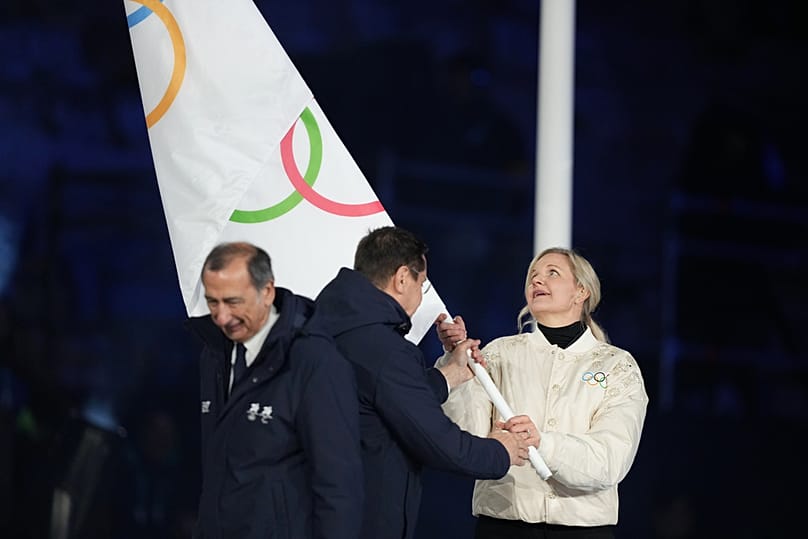 IOC President Kirsty Coventry takes the Olympic flag during the closing ceremony of the 2026 Winter Olympics, in Verona, Italy, Sunday, Feb. 22, 2026