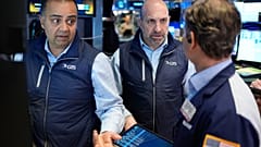 James Denaro in der Mitte und Dilip Patel links arbeiten auf dem Parkett der New York Stock Exchange in New York. 25. März 2026