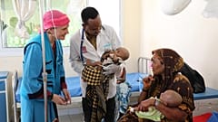 Die UNICEF-Vertreterin in Somalia Sandra Lattouf mit einer Mutter von Zwillingen in einem Krankenhaus im Süden Somalias, 25. März 2026