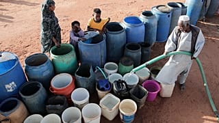 Wolontariusz napełnia pojemniki z wodą w punkcie bezpłatnej dystrybucji z powodu przerw w dostawie wody w Chartumie w Sudanie, 30 stycznia 2026 r. (AP Photo/Marwan Ali)