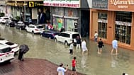 Des habitants avancent dans des rues inondées à Sharjah après de fortes pluies nocturnes