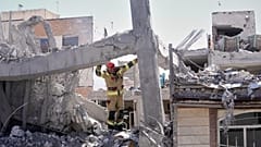 Ein Ersthelfer inspiziert die beschädigte Struktur eines Wohnhauses, das bei einem früheren amerikanisch-israelischen Angriff in Teheran getroffen wurde, 27. März 2026