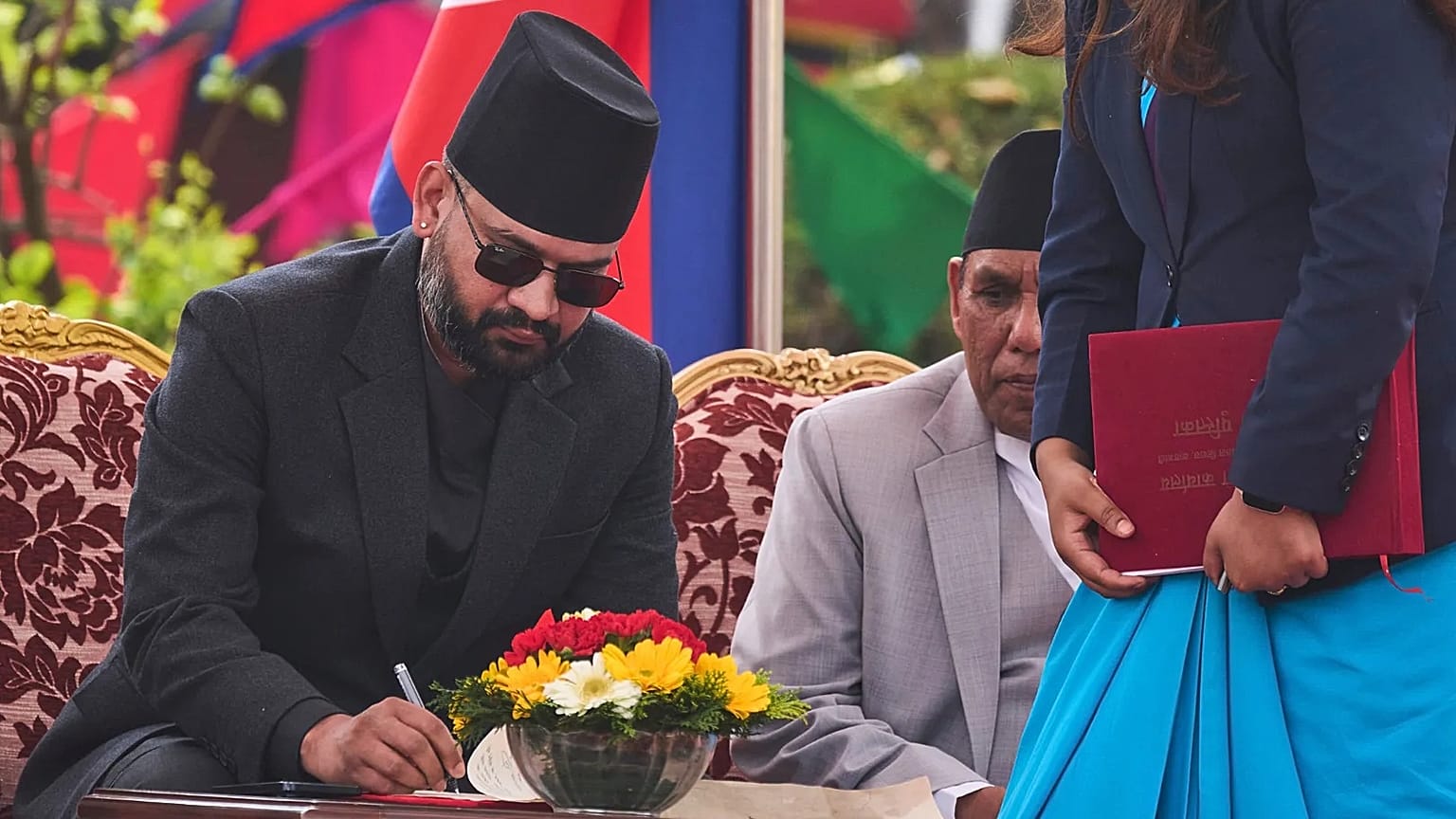 Nepal's youngest Prime Minister Balendra Shah signs documents after taking the oath of office at the Presidential building in Kathmandu, 27 March, 2026