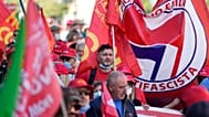 Demonstrators take part in a march organized by Italy's main labor unions, in Rome's St. John Lateran square, Saturday, Oct. 16, 2021.