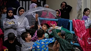 أطفال نازحون يحتمون تحت مظلة مع هطول الأمطار في مدرسة تحولت إلى ملجأ في مدينة صيدا الساحلية الجنوبية بلبنان، الجمعة 20 مارس 2026. 