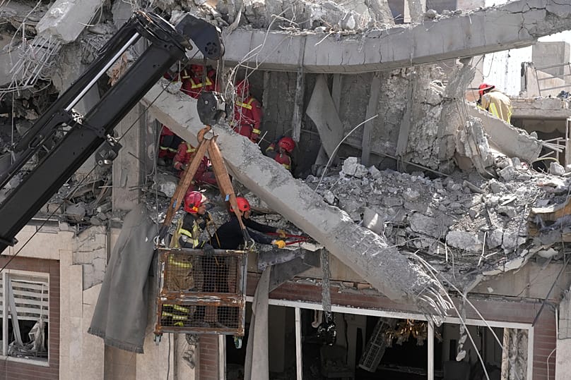 First responders work to remove a body from the rubble of a residential building hit in an overnight strike in Tehran, 27 March, 2026
