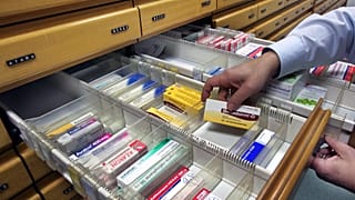 * صيدلي يأخذ الدواء من درج خزانة الصيدلية في فرانكفورت أم ماين 