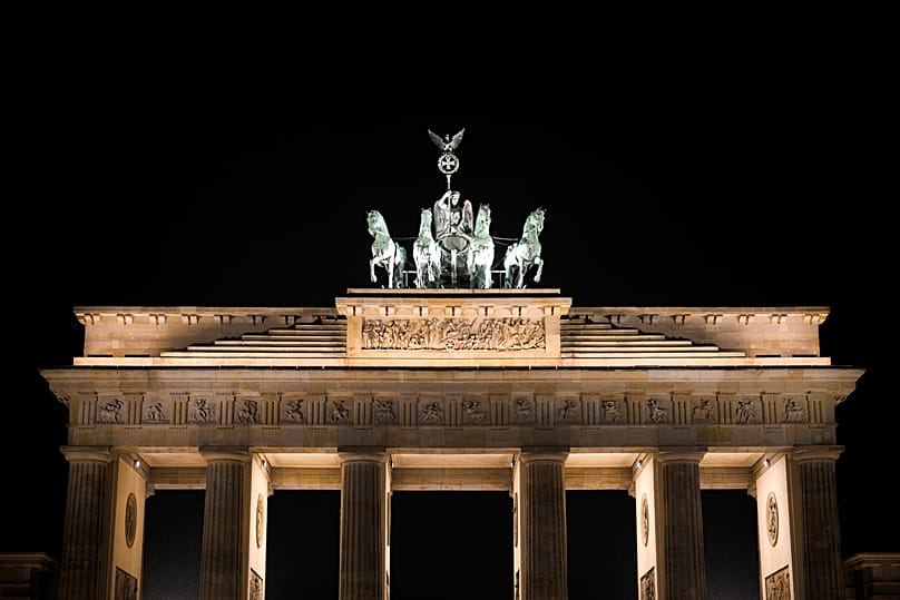 A Quadriga no topo do emblemático Portão de Brandemburgo, na Alemanha, é iluminada pouco antes da Hora do Planeta, em Berlim, Alemanha, no sábado, 25 de março de 2023. 