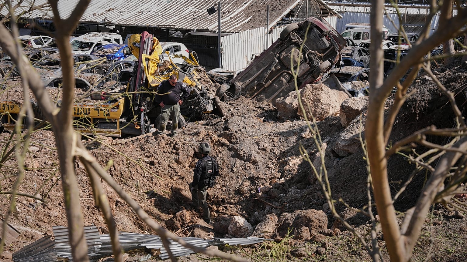 Izraeli biztonsági erők vizsgálják egy iráni rakétacsapás helyszínét Eshtaolban, Izrael középső részén