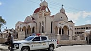 عنصر في قوى الأمن الداخلي السوري يجلس على سيارة متوقفة خارج كنيسة في بلدة السقيلبية ذات الأغلبية المسيحية، غرب حماة، سوريا، السبت 28 مارس 2026، 