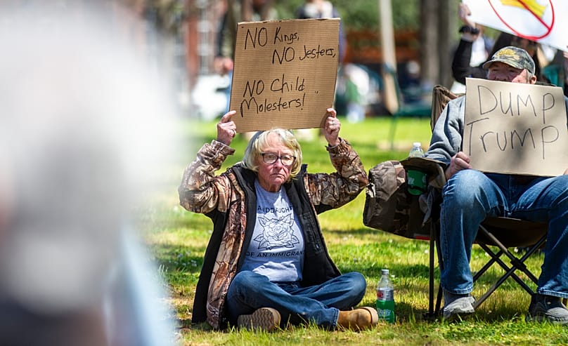 Demonstrators hold signs during the "No Kings" rally at Wilson Park in Florence, Ala, on Saturday, 28 March, 2026.
