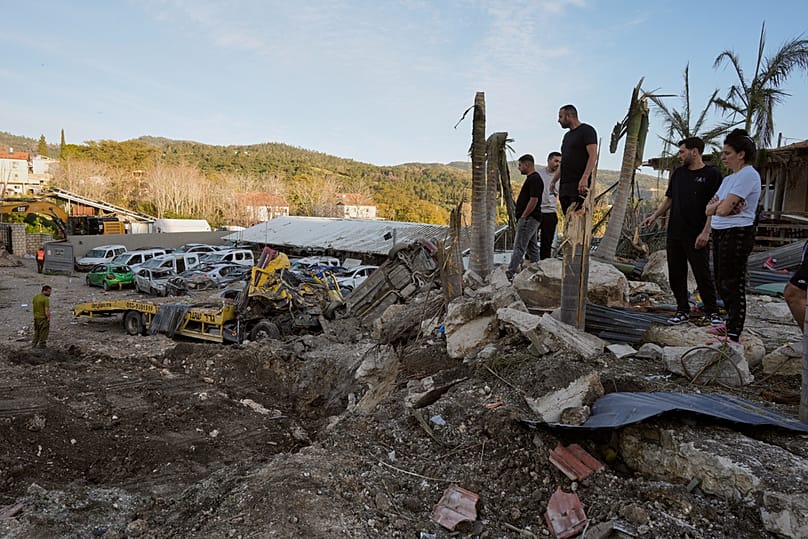 Residents examine the site of an Iranian missile strike in Eshtaol, central Israel, Saturday, March 28, 2026