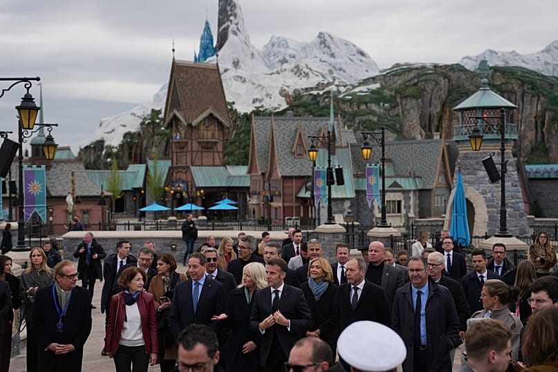 Le président français Emmanuel Macron s'entretient avec des employés lors de sa visite à Disneyland Paris, le vendredi 27 mars 2026.