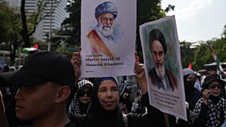 امرأة تعرض صورة المرشد الأعلى الإيراني الراحل آية الله علي خامنئي.