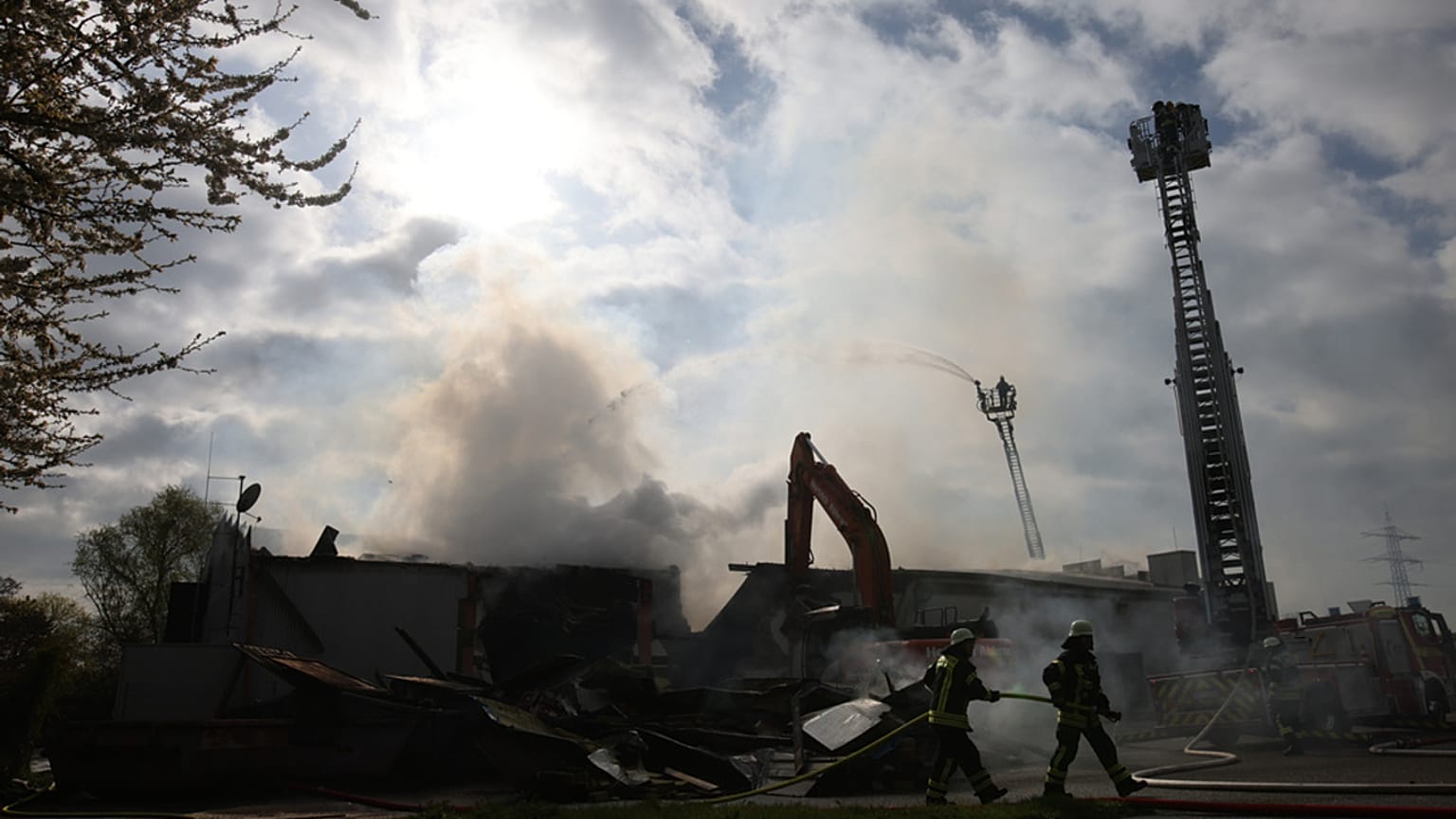 Des pompiers utilisent des engins lourds pour se frayer un chemin jusqu'aux poches de braises après un incendie dans une boîte de nuit à Kehl, en Allemagne, le dimanche 29 mar
