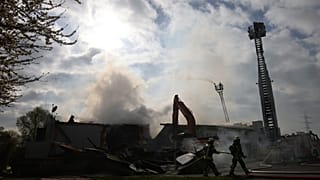 Des pompiers utilisent des engins lourds pour se frayer un chemin jusqu'aux poches de braises après un incendie dans une boîte de nuit à Kehl, en Allemagne, le dimanche 29 mar