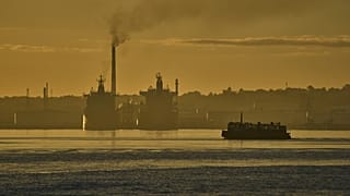 A ferry crosses Havana Bay past the Nico Lopez oil refinery where Cuban tankers are anchored in Havana Bay, 24 March 2026