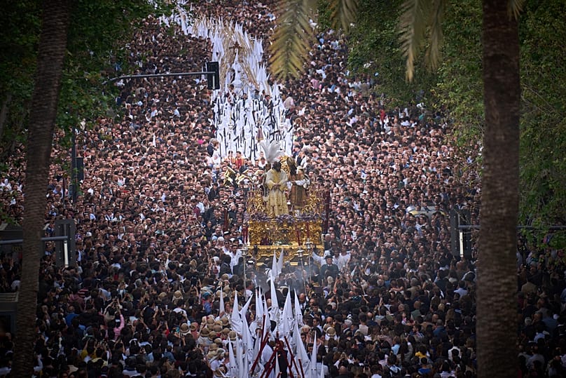 Los fieles contemplan una procesión de Semana Santa de los penitentes de la cofradía de San Gonzalo en Sevilla, España, el 14 de abril de 2025.