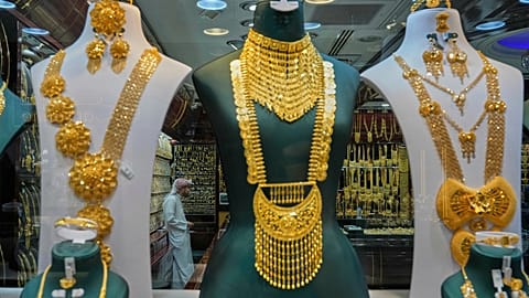 FILE. A shopkeeper waits for customers as jewelry is displayed at a gold market in Dubai, UAE, Apr. 2025
