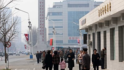 Des passants marchent dans une rue du district central de Pyongyang, mercredi 25 mars 2026.