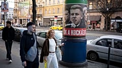 Passanten gehen an einem Wahlplakat vorbei, auf dem steht: „Sie sind ein Risiko. Fidesz ist die sichere Wahl“, in Budapest am 14. März 2026 vor der Parlamentswahl.