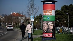 Pessoas caminham ao lado de um cartaz de campanha que diz: "Eles são um risco. O Fidesz é a escolha segura" em Budapeste, Hungria, no sábado, 14 de março de 2026, antes das eleições legislativas de 12 de abril.