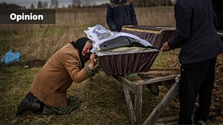 FILE - Nadiya Trubchaninova, 70, cries while holding the coffin of her son Vadym, 48, in the cemetery of Mykulychi, Ukraine, April 16, 2022