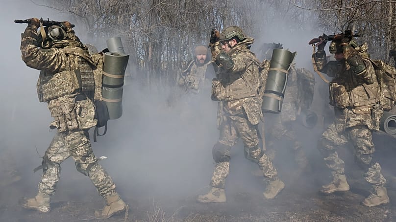 In this photo provided by Ukraine's 65th Mechanized Brigade press service, recruits practice military drills at a training ground in the Zaporizhzhia region, Ukraine, Sunday, 