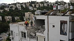 Israelische Behörden inspizieren ein beschädigtes Haus nach einem iranischen Raketeneinschlag in Haifa, Israel, Montag, 30. März 2026. 