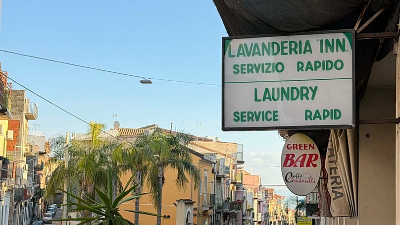 Attività commerciali con cartelli in inglese a Motta Sant’Anastasia, maggio 2026