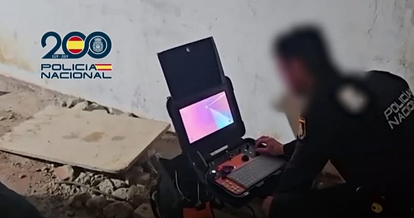 A police officer watches a video as officers make their way through the tunnel found in Ceuta