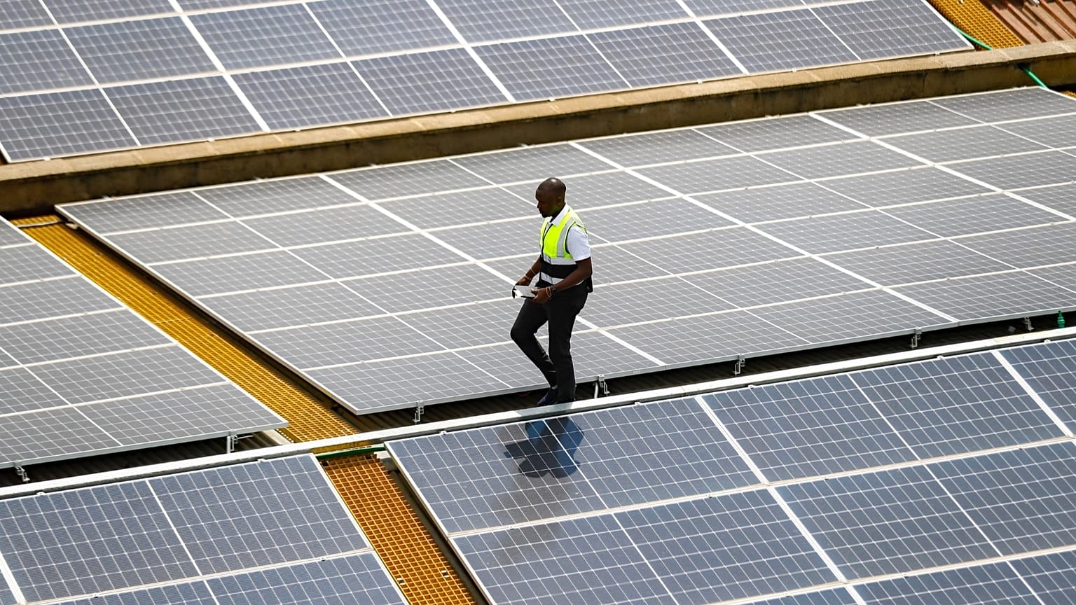 Mark Munyua, technik CP Solar, sprawdza panele słoneczne na dachu firmy w Nairobi w Kenii, 1 września 2023 r.