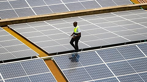 Mark Munyua, CP solar's technician, examines solar panels on the roof of a company in Nairobi, Kenya, Friday, Sept. 1, 2023