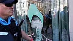 DATEI (01.05.2023). Demonstranten und Polizisten spiegeln sich während einer Demonstration zum Tag der Arbeit in Lissabon am Montag in einem Hotelfenster.