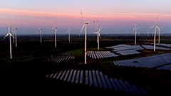 Almanya'nın Klettwitz kenti yakınlarındaki Klettwitz Nord güneş enerjisi parkında güneş doğarken rüzgar türbinleri çalışıyor, 16 Ekim 2024 Çarşamba.