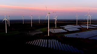 Almanya'nın Klettwitz kenti yakınlarındaki Klettwitz Nord güneş enerjisi parkında güneş doğarken rüzgar türbinleri çalışıyor, 16 Ekim 2024 Çarşamba.