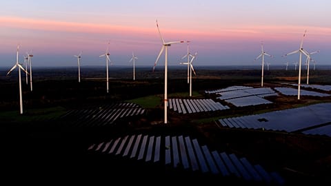 Wind turbines operate as the sun rises at the Klettwitz Nord solar energy park near Klettwitz, Germany, Wednesday, Oct. 16, 2024. 