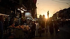 Menschen spazieren auf einem lokalen Markt in der Nähe des Kadhimiya-Schreins bei Sonnenuntergang in Bagdad, 31. März 2026
