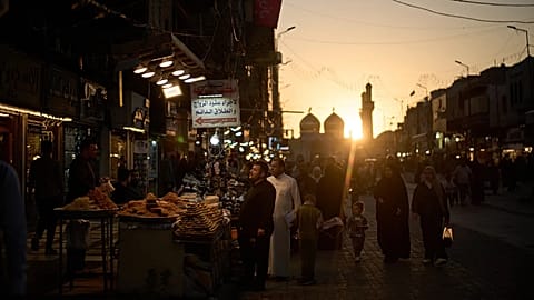 People walk at a local market near the Kadhimiya Shrine at sunset in Baghdad, 31 March, 2026