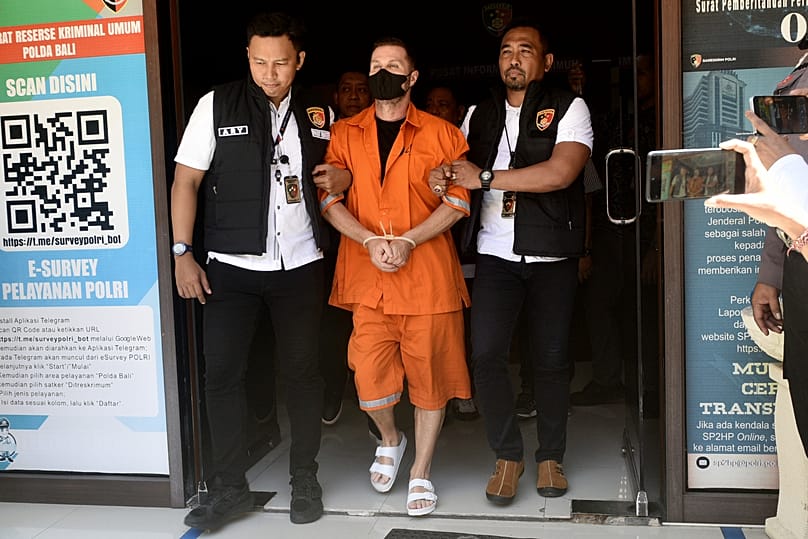 Steven Lyons, described as a senior figure in an international crime syndicate, is escorted by police officers at the regional police headquarters in Denpasar, 31 March, 2026