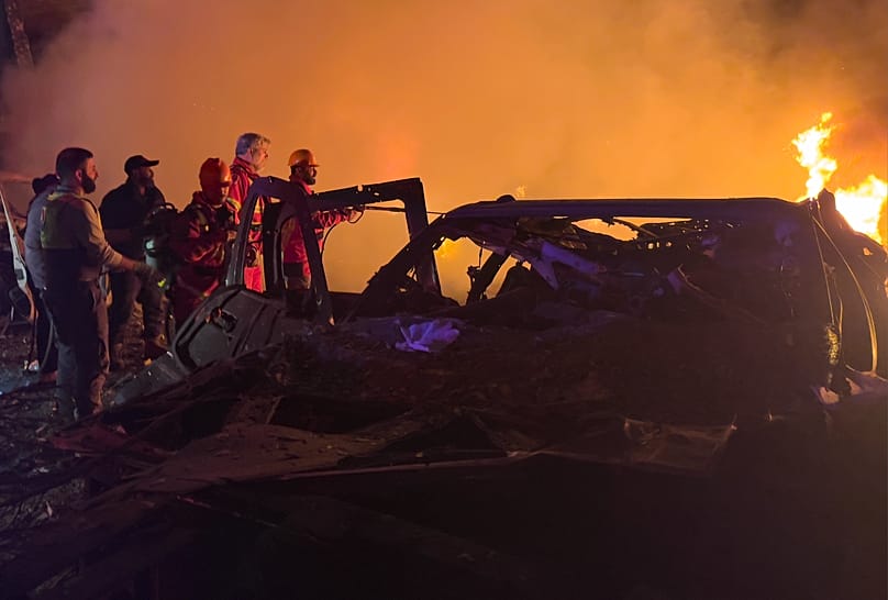Rescue workers inspect the scene of an Israeli airstrike as fires burn among damaged vehicles, in Beirut, Lebanon, Wednesday, April 1, 2026.