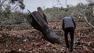 يتفقد رجل حطام صاروخ إيراني سقط في الضفة الغربية، الثلاثاء 31 مارس/آذار 2026. 