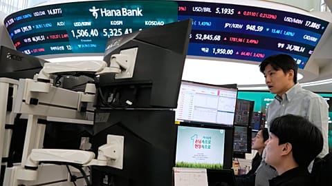 Currency traders watch monitors near a screen showing the KOSPI, South Korea, 1 April 2026